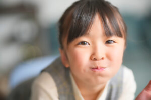 女の子がほほを膨らましてお口の体操をしている写真